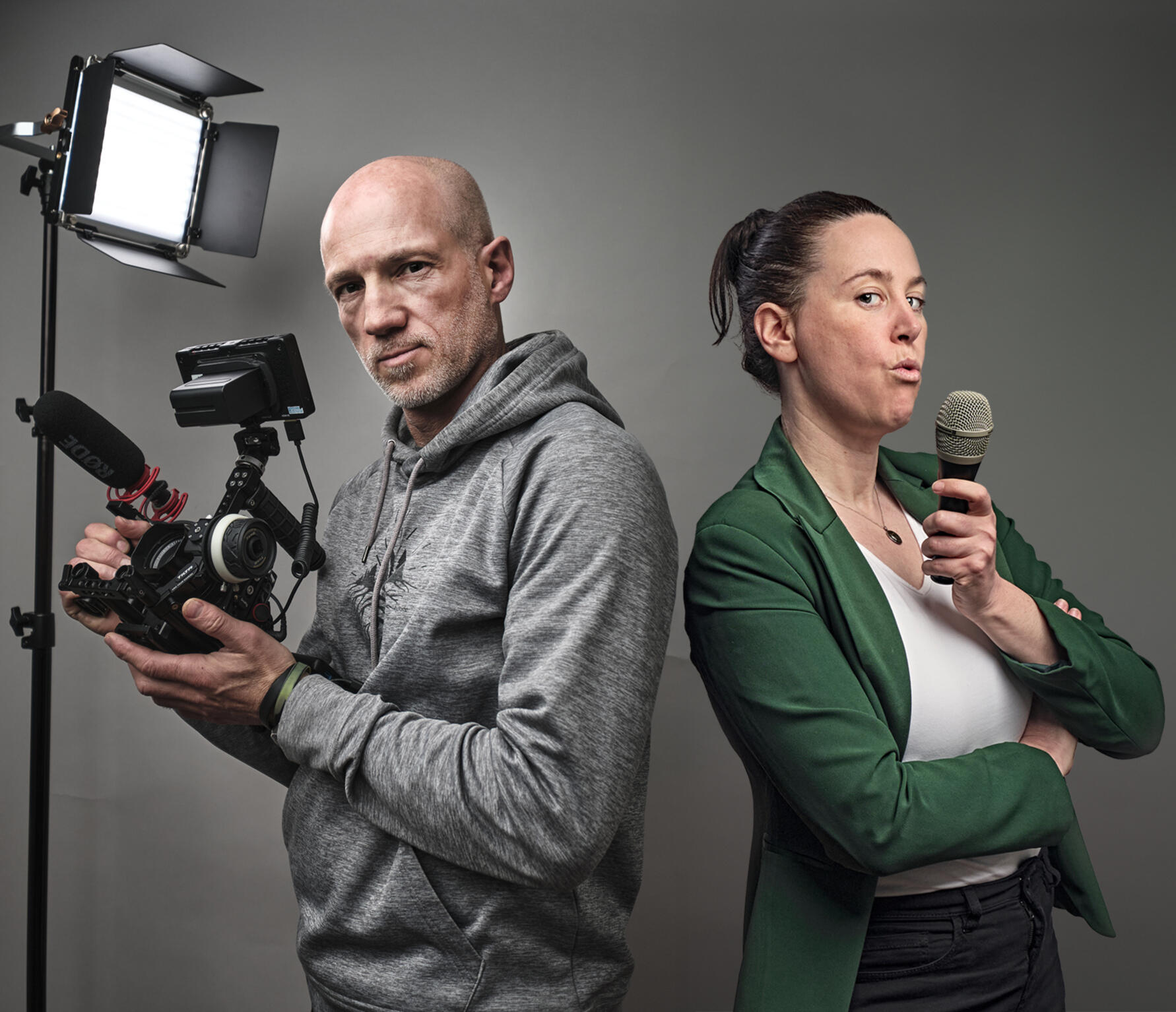 Alex Harris and Sarah Martens blowing imaginary smoke from their camera and microphone as if from smoking guns.